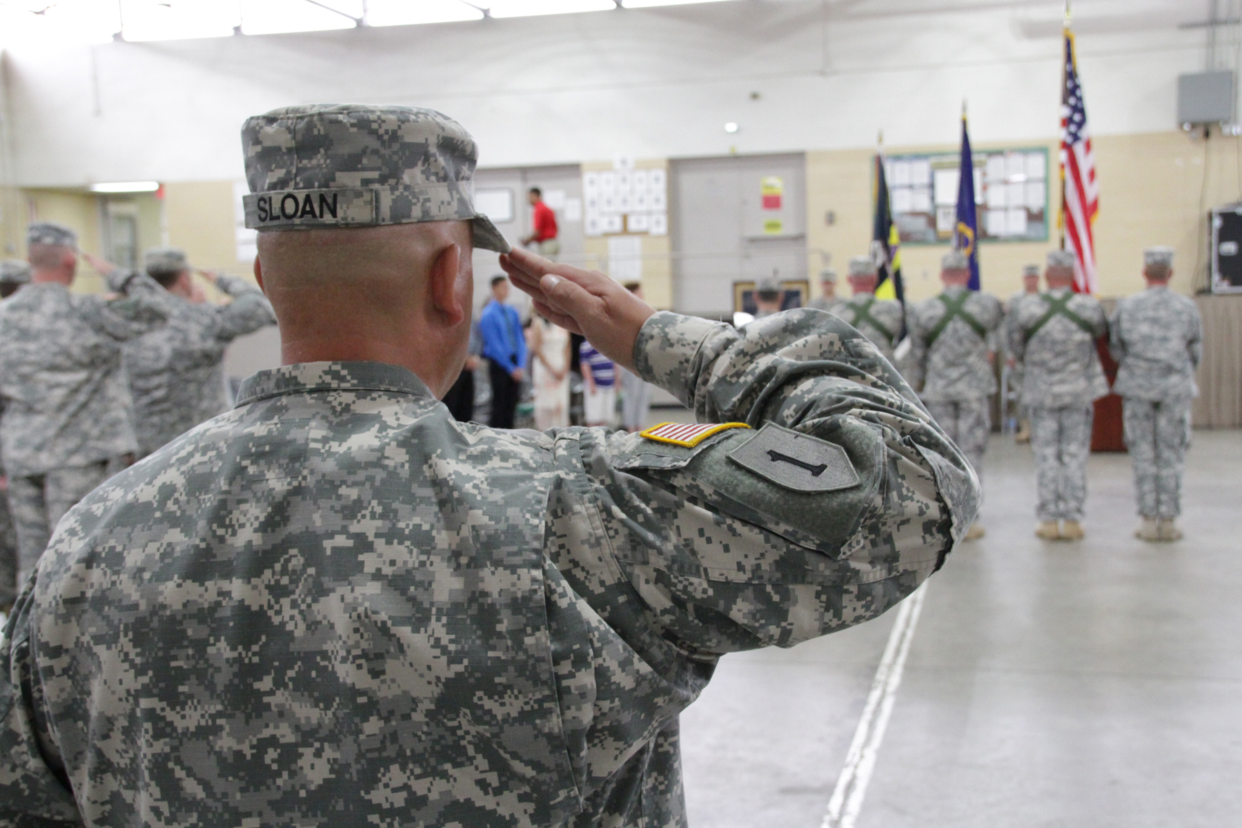 military men saluting at a ceremony and wearing uniforms