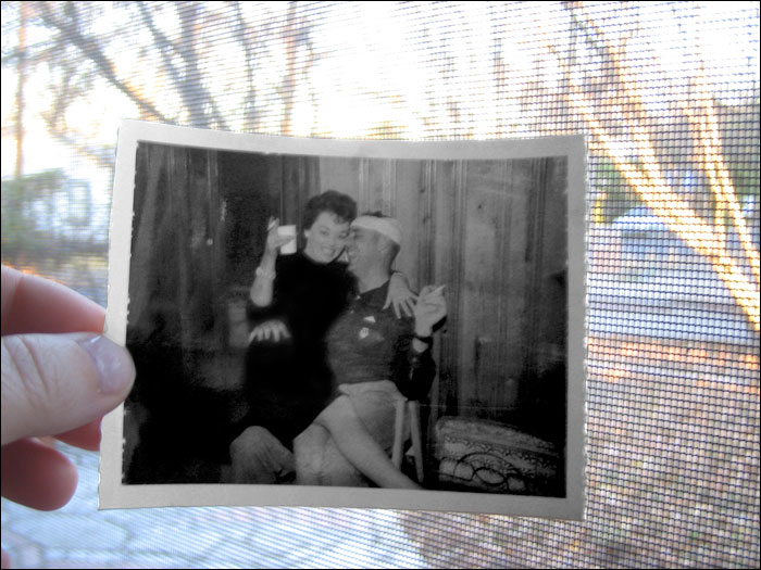 a person holds an old po of a couple in their bedroom