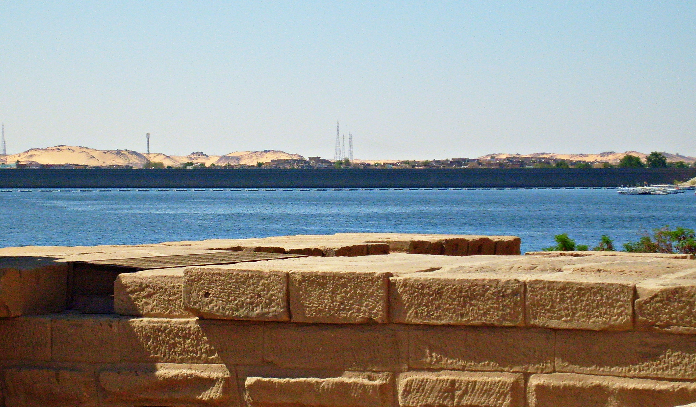 a bench sitting in the sand near the water