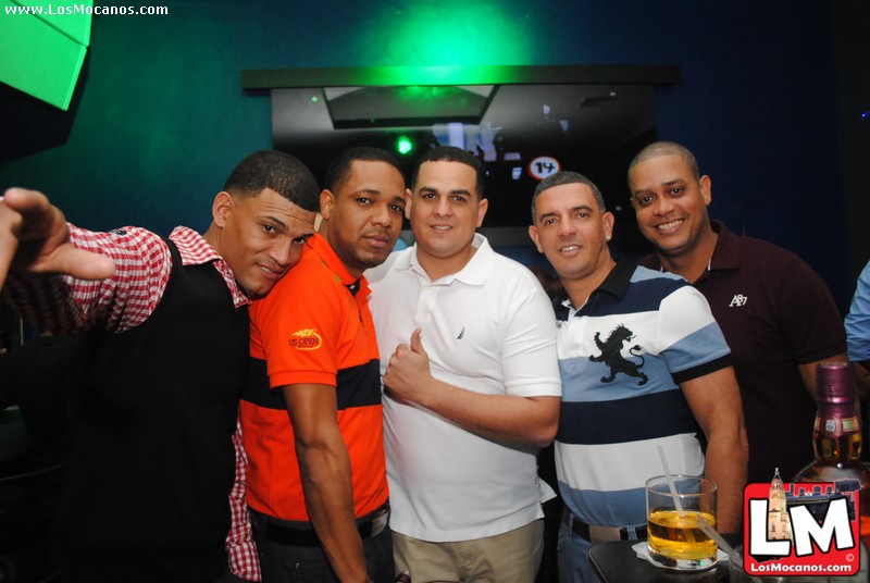 a group of men taking pictures together at a bar