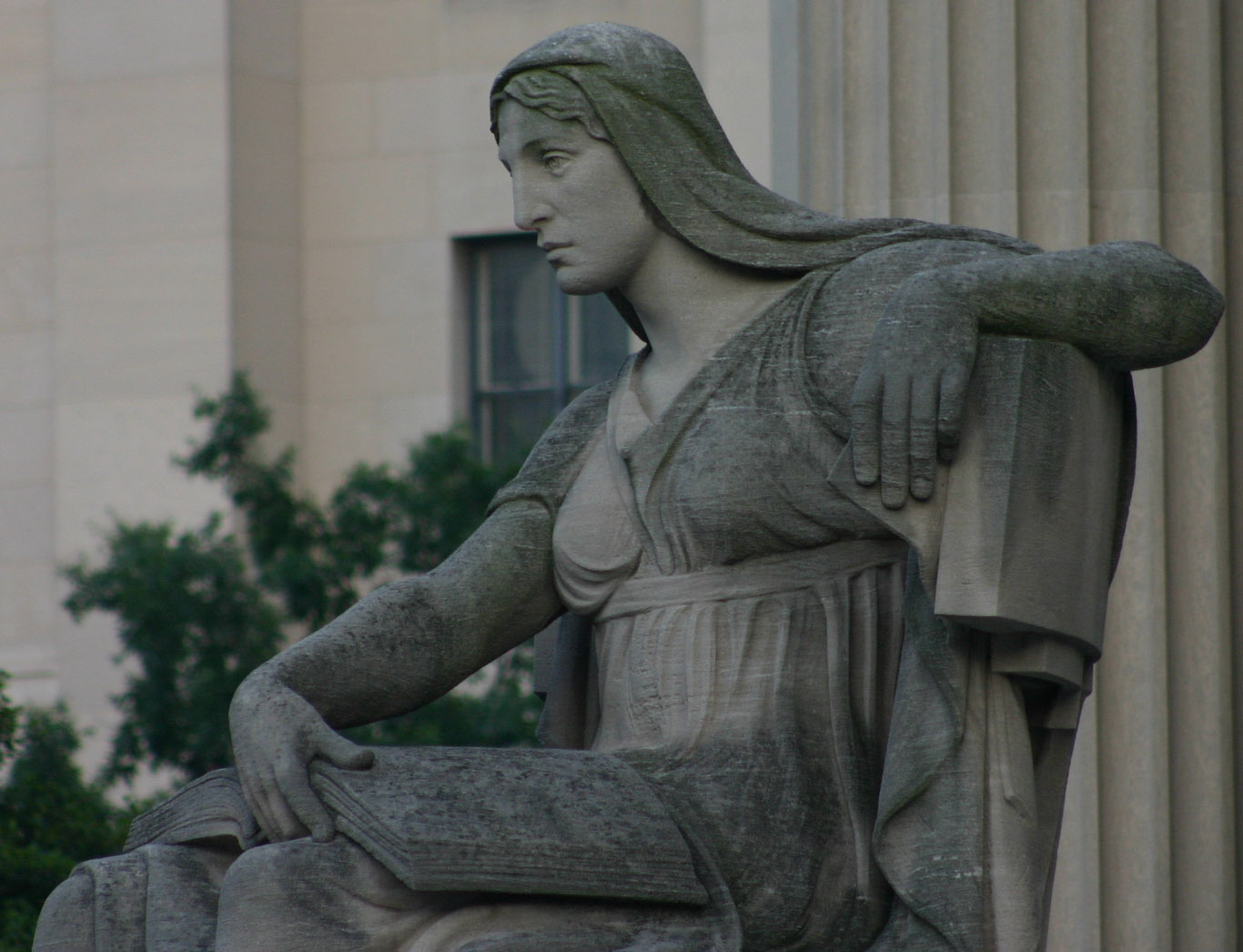 a statue is next to a tall building