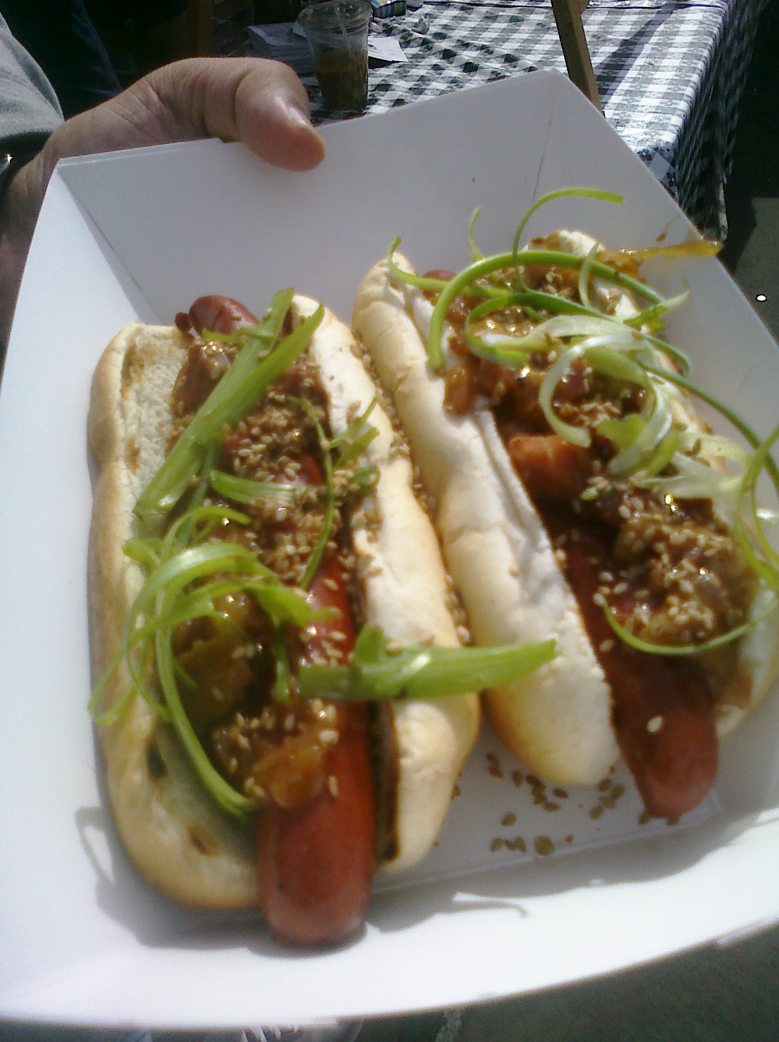 two dogs with green onions in a white container