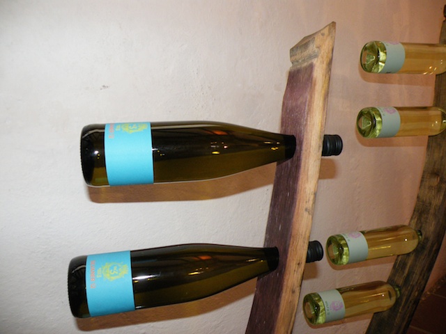 three wine bottles mounted on the back of a wooden structure