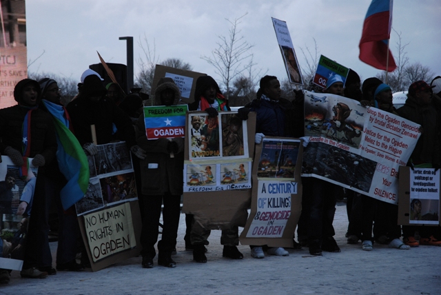 a group of people holding placards standing in the snow