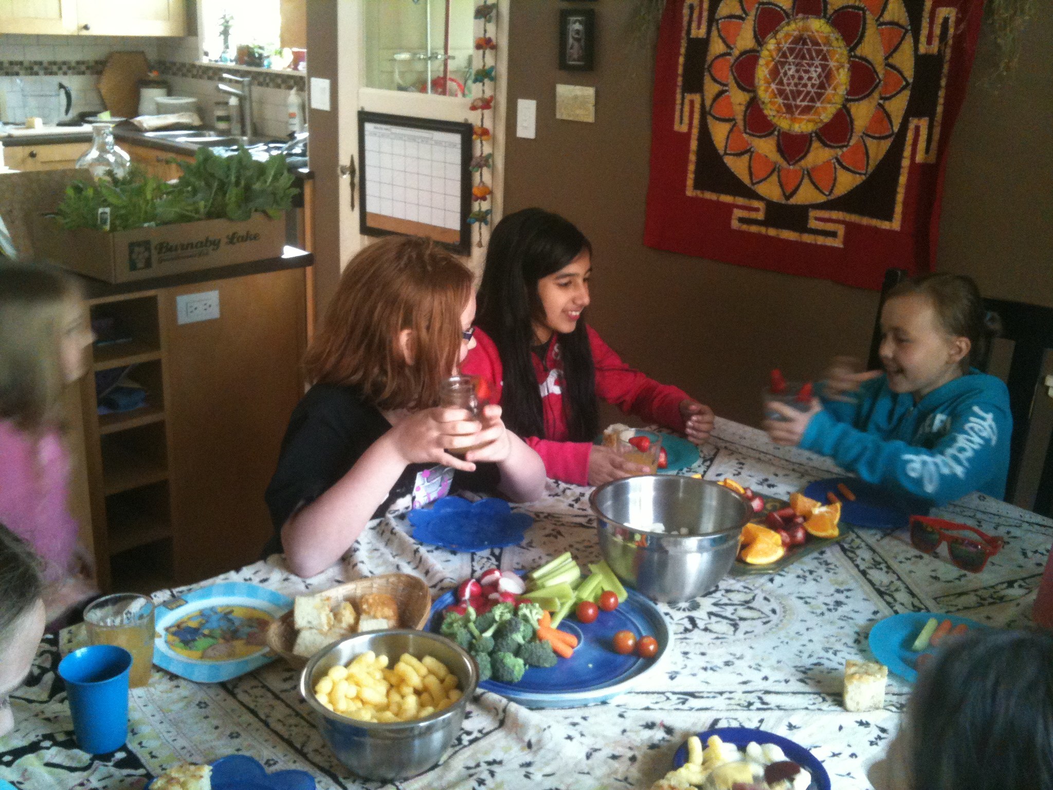 a group of s and adults enjoying food on a table