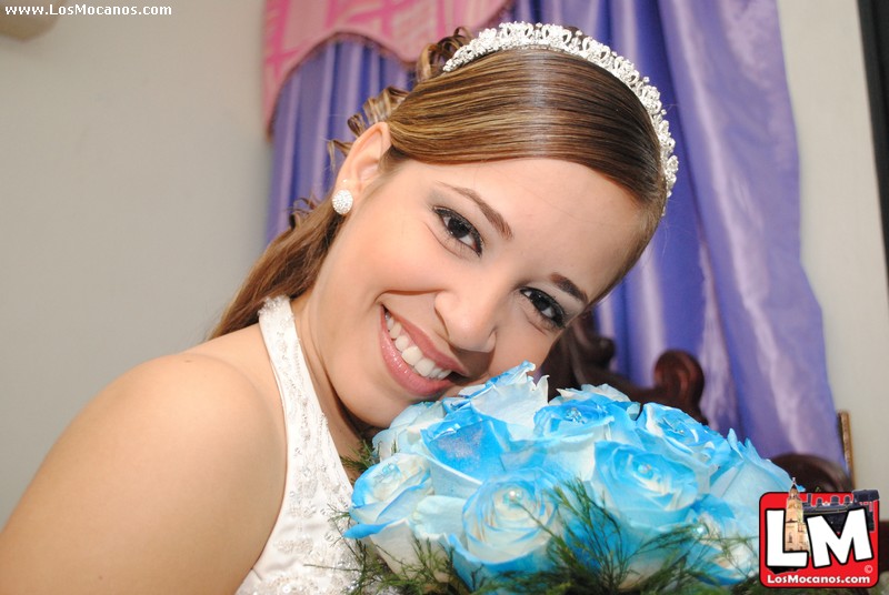 a smiling bride holding a flower bouquet at a wedding