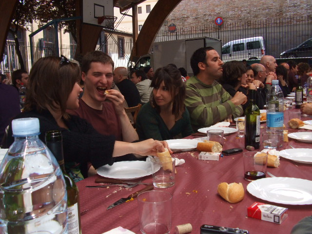 people sitting at a long table eating food