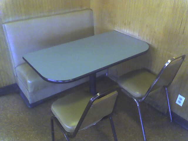 a dinette table in a corner with three chairs around it