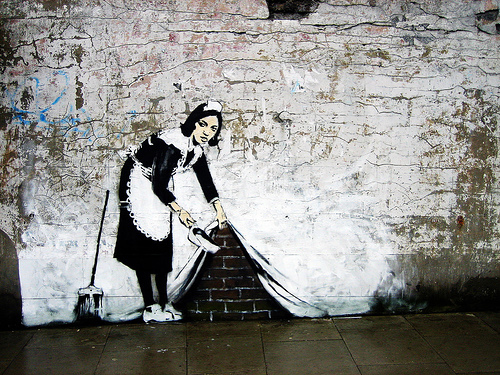 the painting on the wall depicts a woman holding a mop
