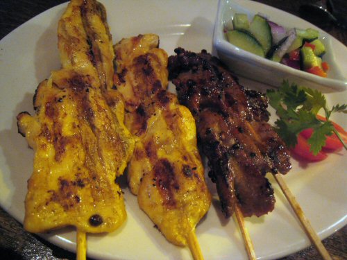 an image of a plate of grilled chicken on skewers