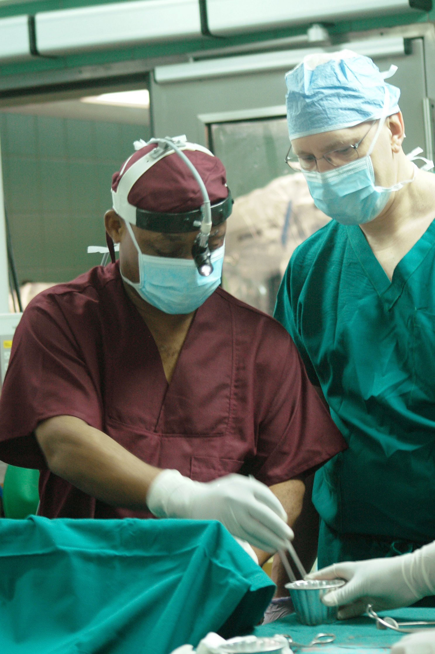 two surgeons in scrubs and maskes preparing to perform 
