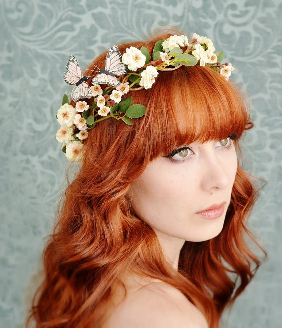 a woman with red hair wearing a crown of flowers