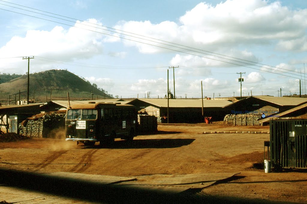 a dirt covered dirt field next to buildings and hills