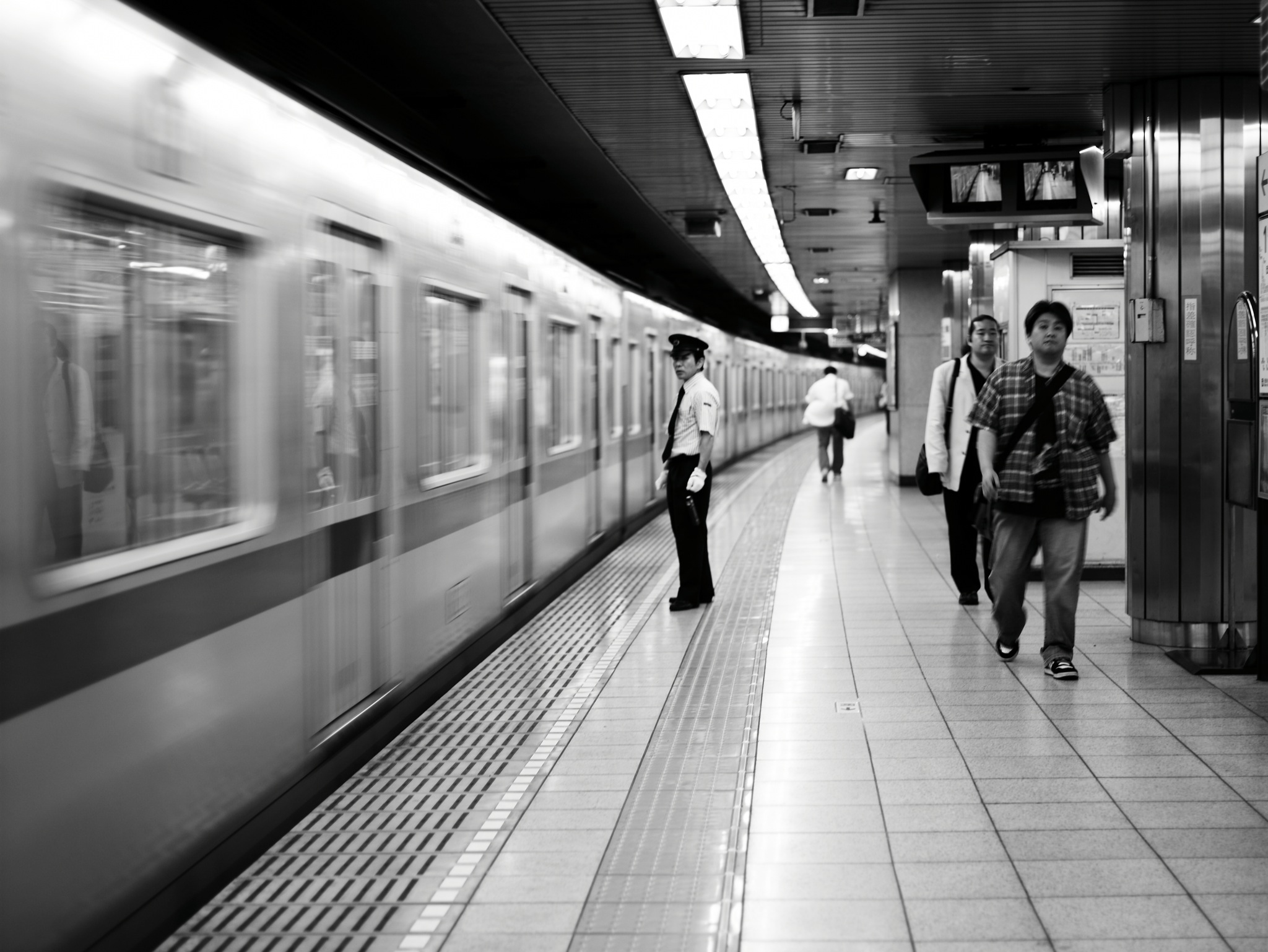 a group of people are walking down the platform