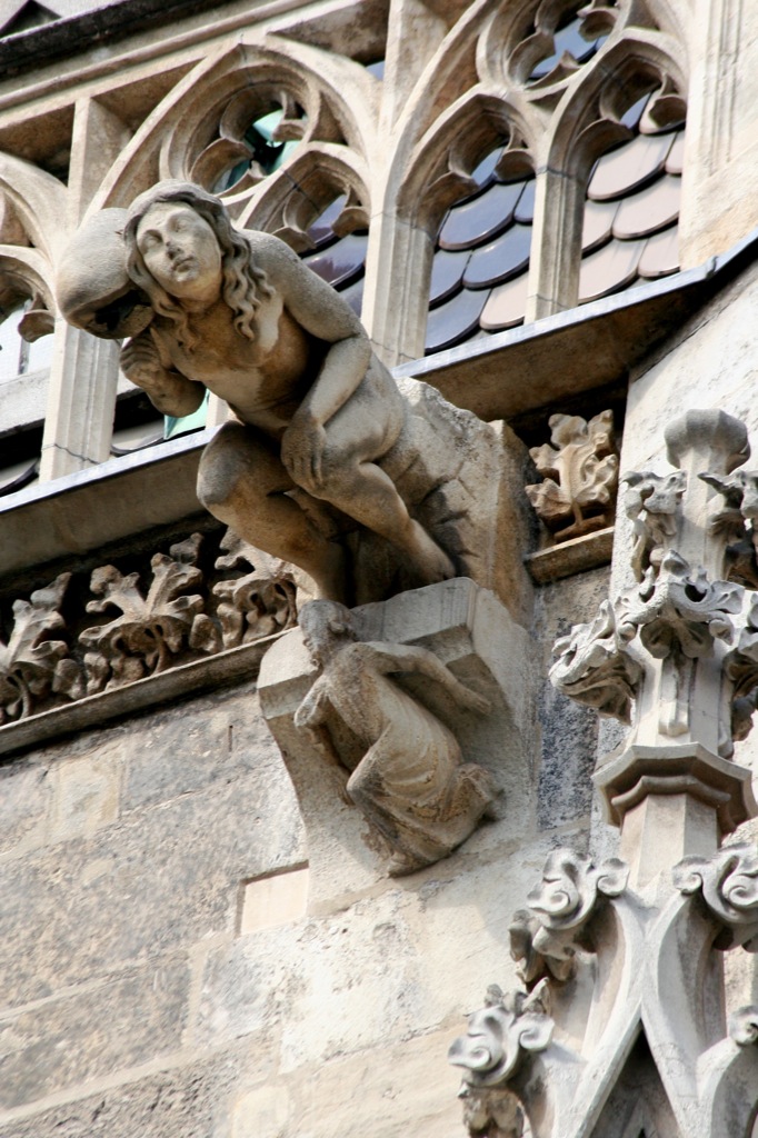 a statue sitting on the side of a tall building