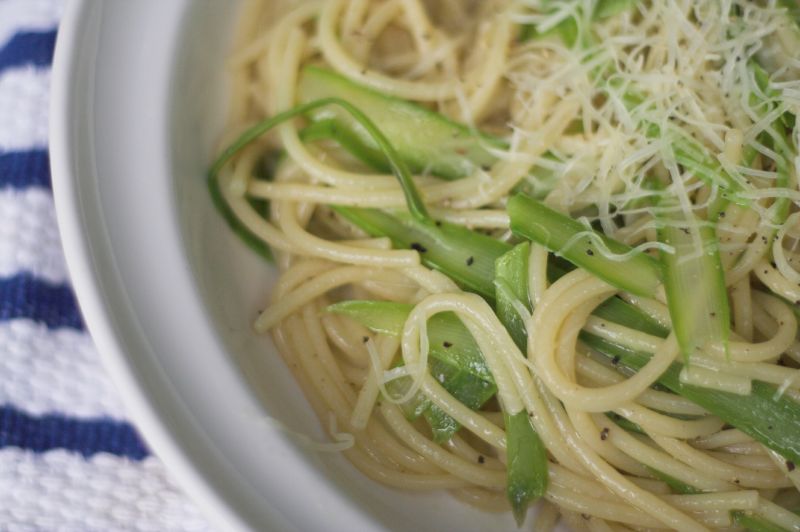 the white plate is filled with pasta and green beans