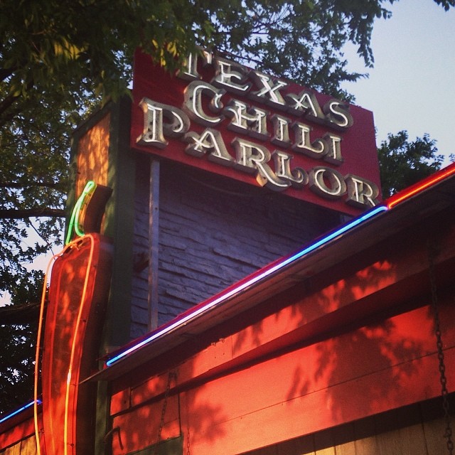 an old fashioned theater with a neon sign on top