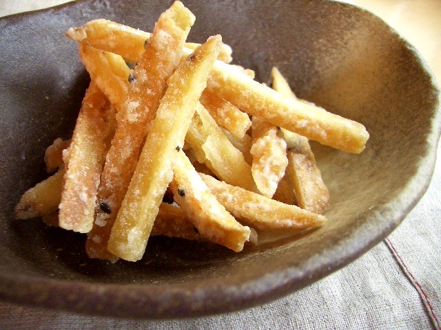 a black bowl has a pile of small cooked fries