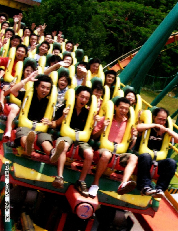 group of people sitting in a ride in a park