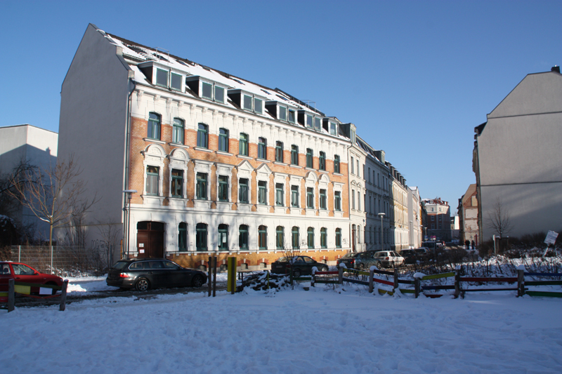 a very big building that has some cars in the snow