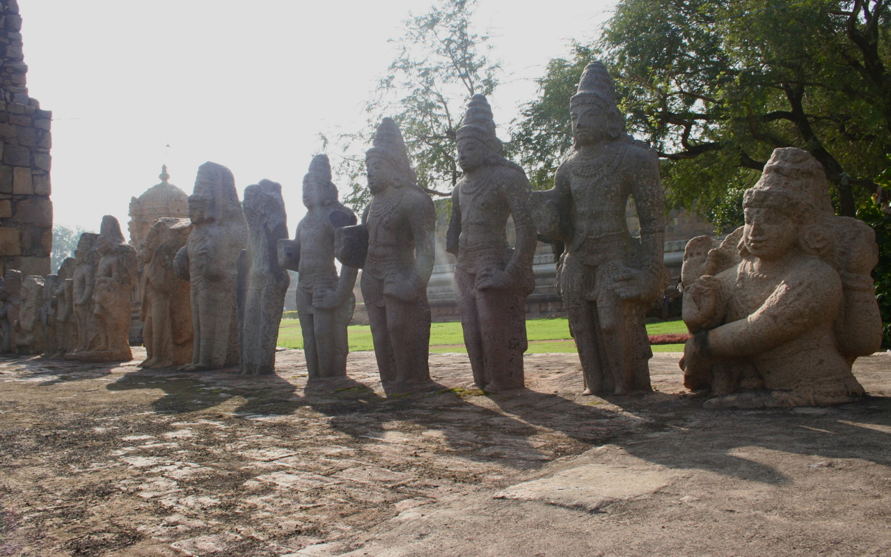 many statues are arranged on cement near trees