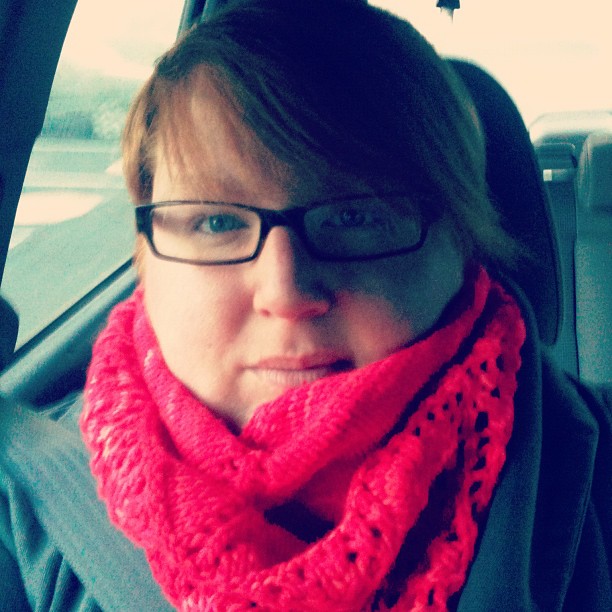 a woman in a car wearing a red scarf