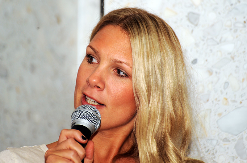 a blond woman is standing with her hands on the microphone