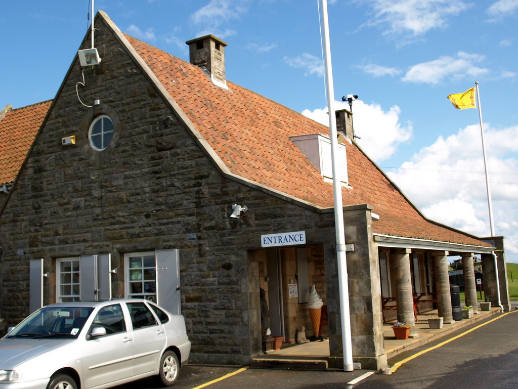 a small, old stone building with a red roof