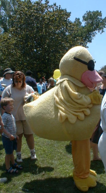 a large stuffed duck and a little boy with their hands