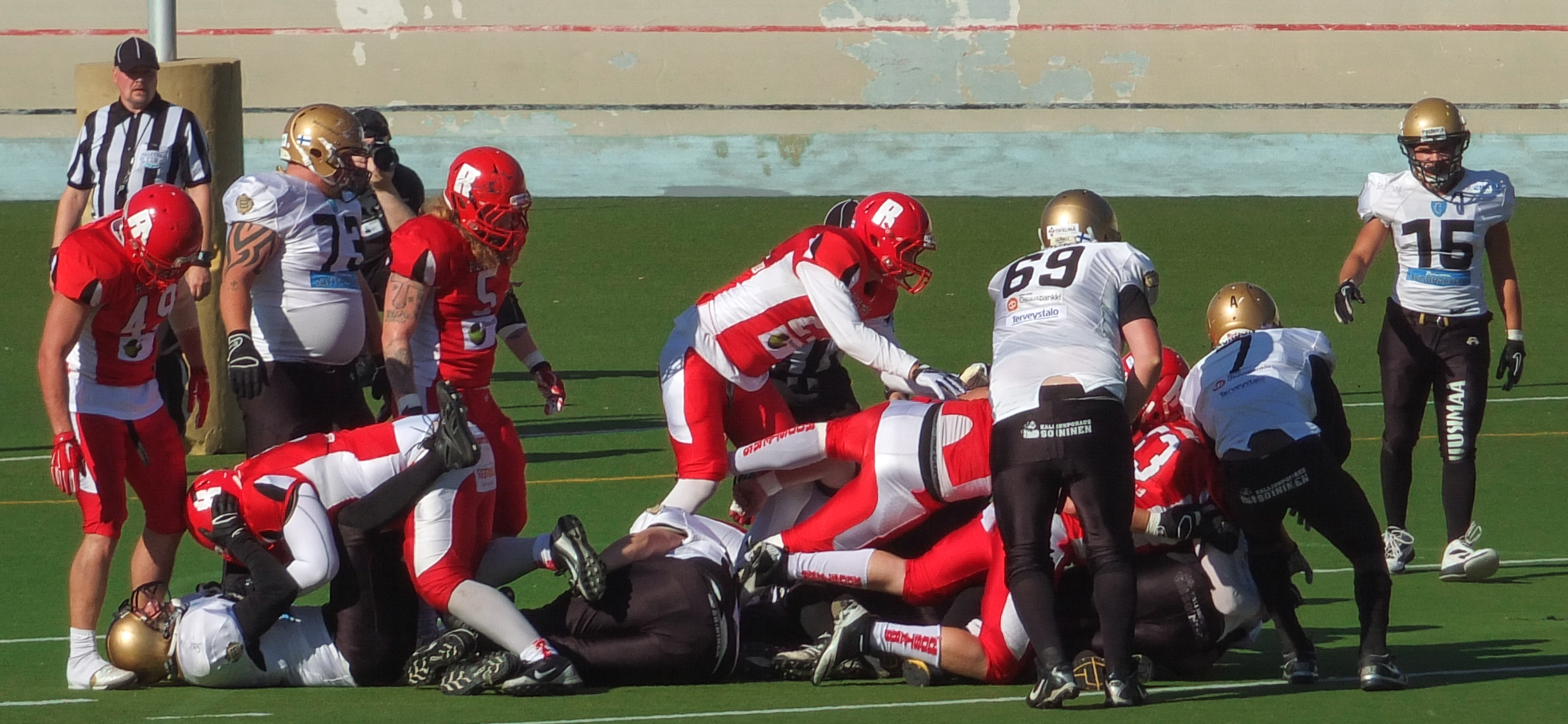 a football game is being played as a group of people stand around on the field