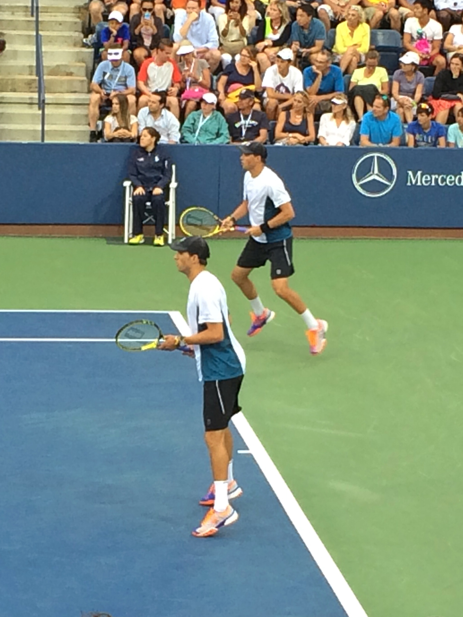 two men playing a game of tennis in front of a crowd