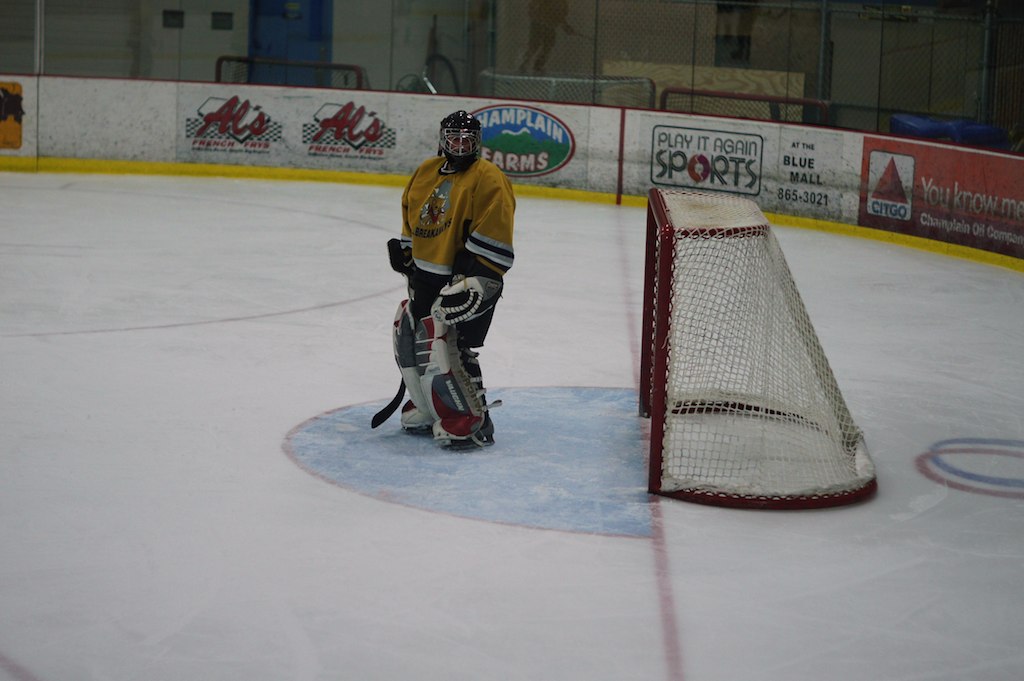 a hockey player looks out at an empty net