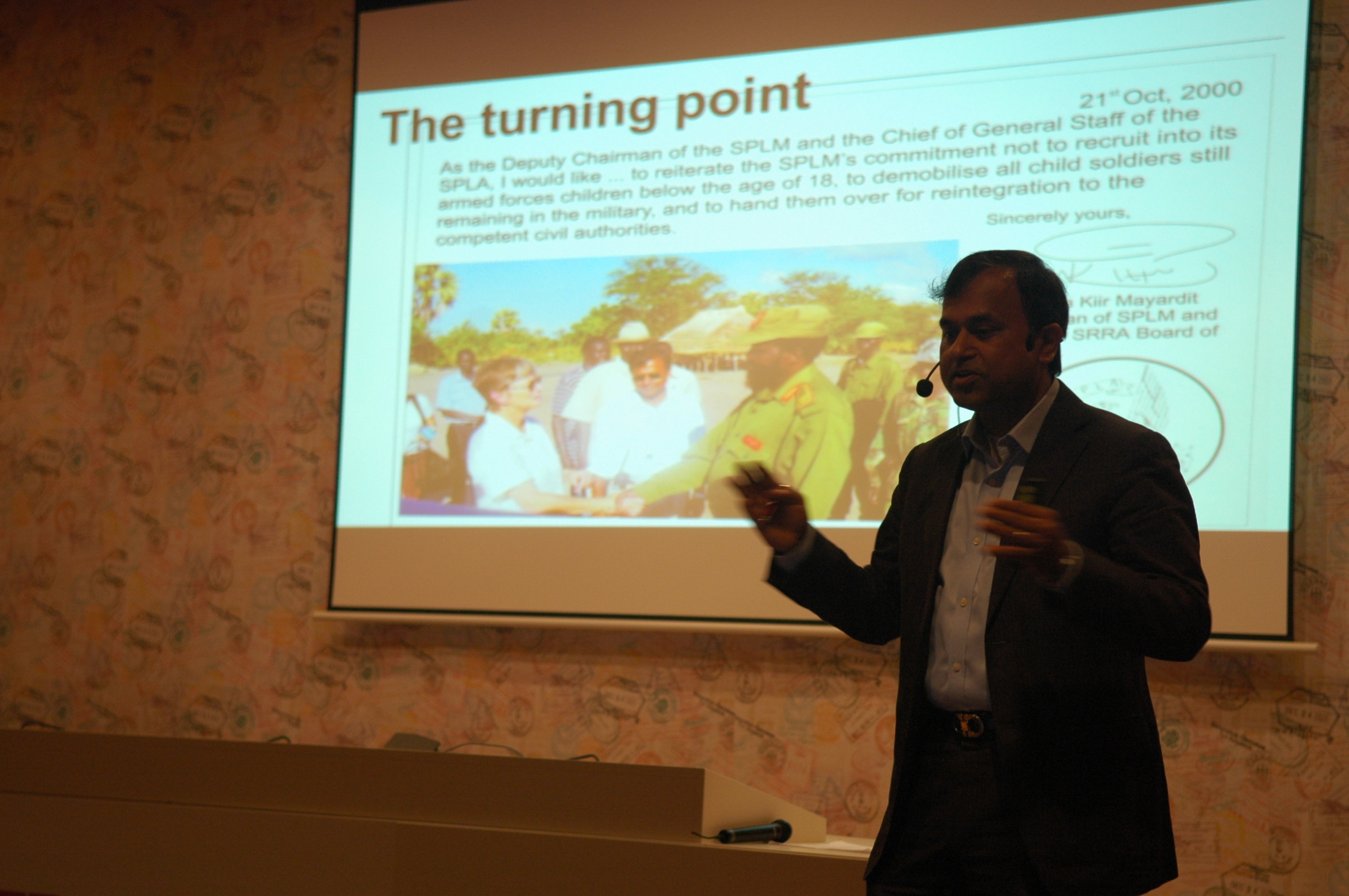 a man giving a talk to a crowd at a conference