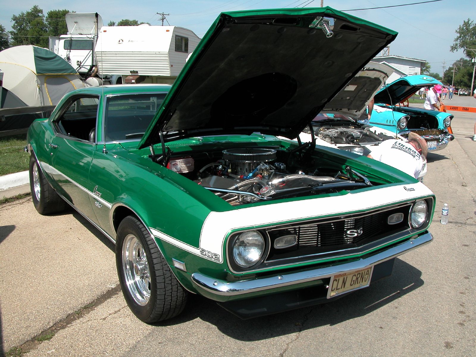 a green and white car with its hood open