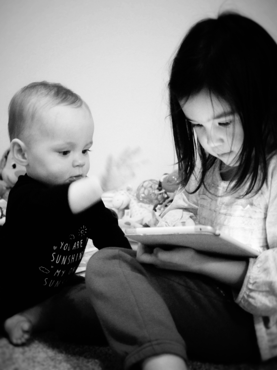 a baby and an adult looking at the pages of a book