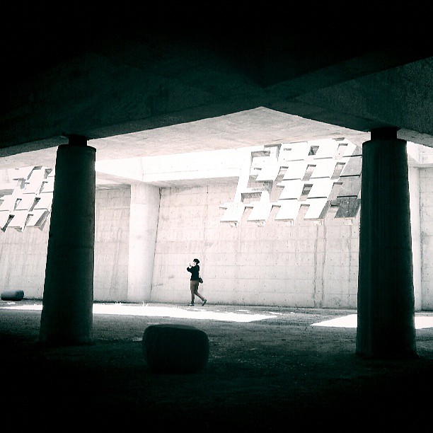 a man standing under an overpass with two columns
