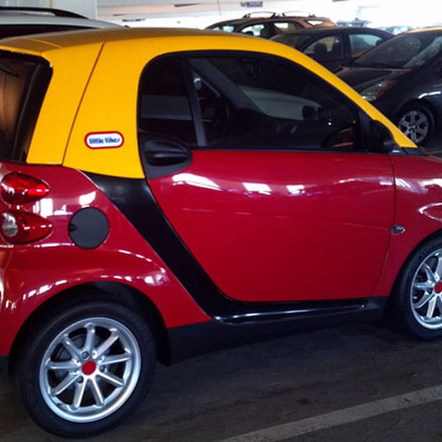 a smart car parked in a garage for people to park