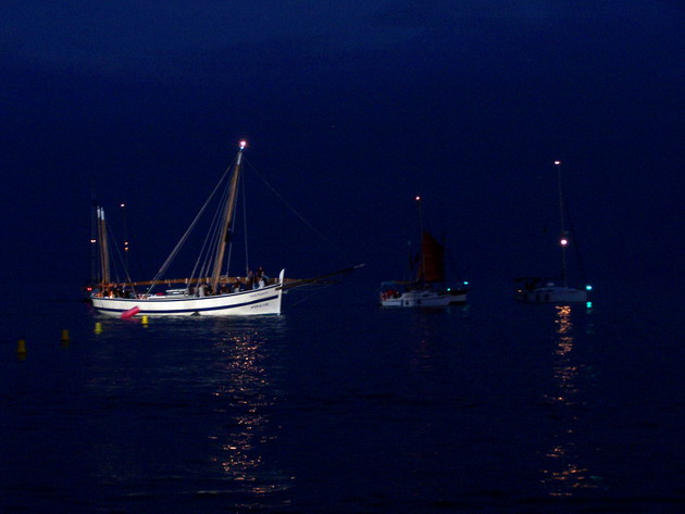 a boat floats in the water with other boats in the background