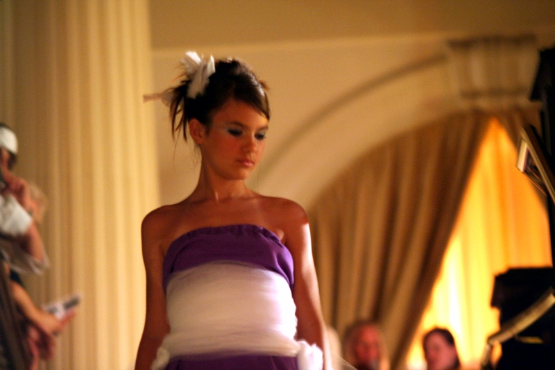 a woman is wearing a purple and white dress