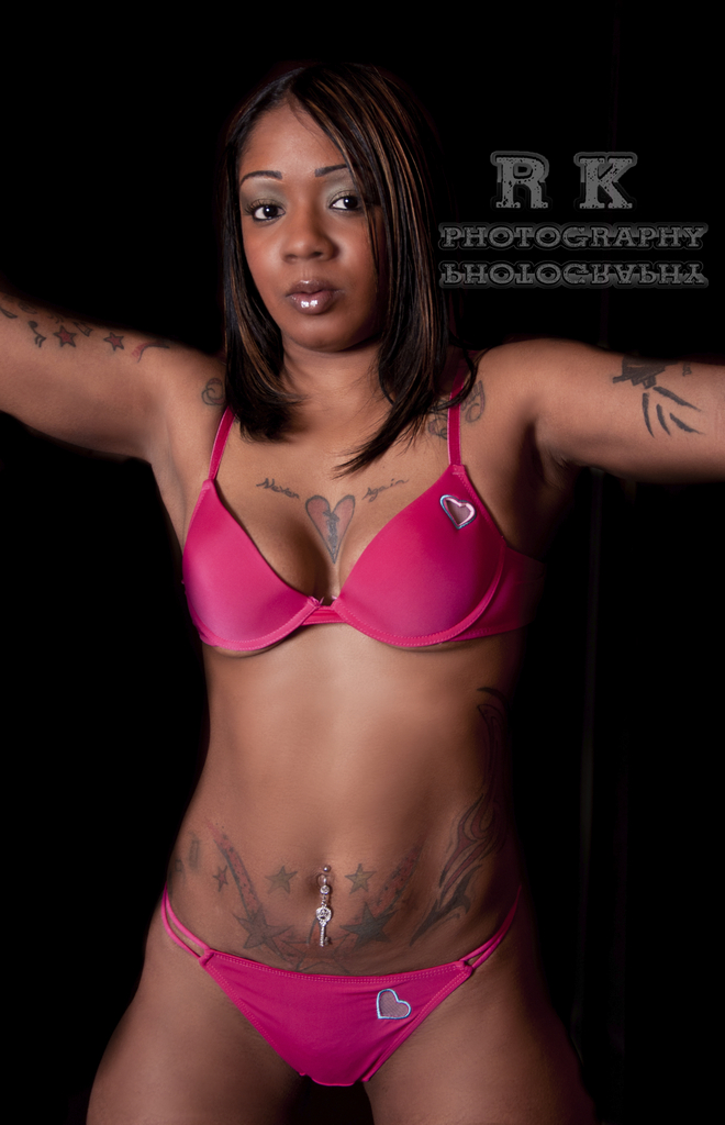 an attractive black woman in pink bikini with tattoos