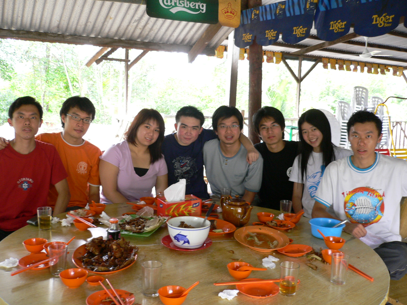 a group of people sitting around a table covered in food