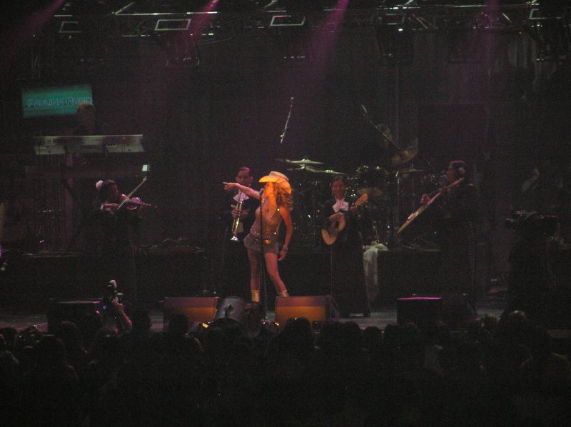 lady with large  on stage and band