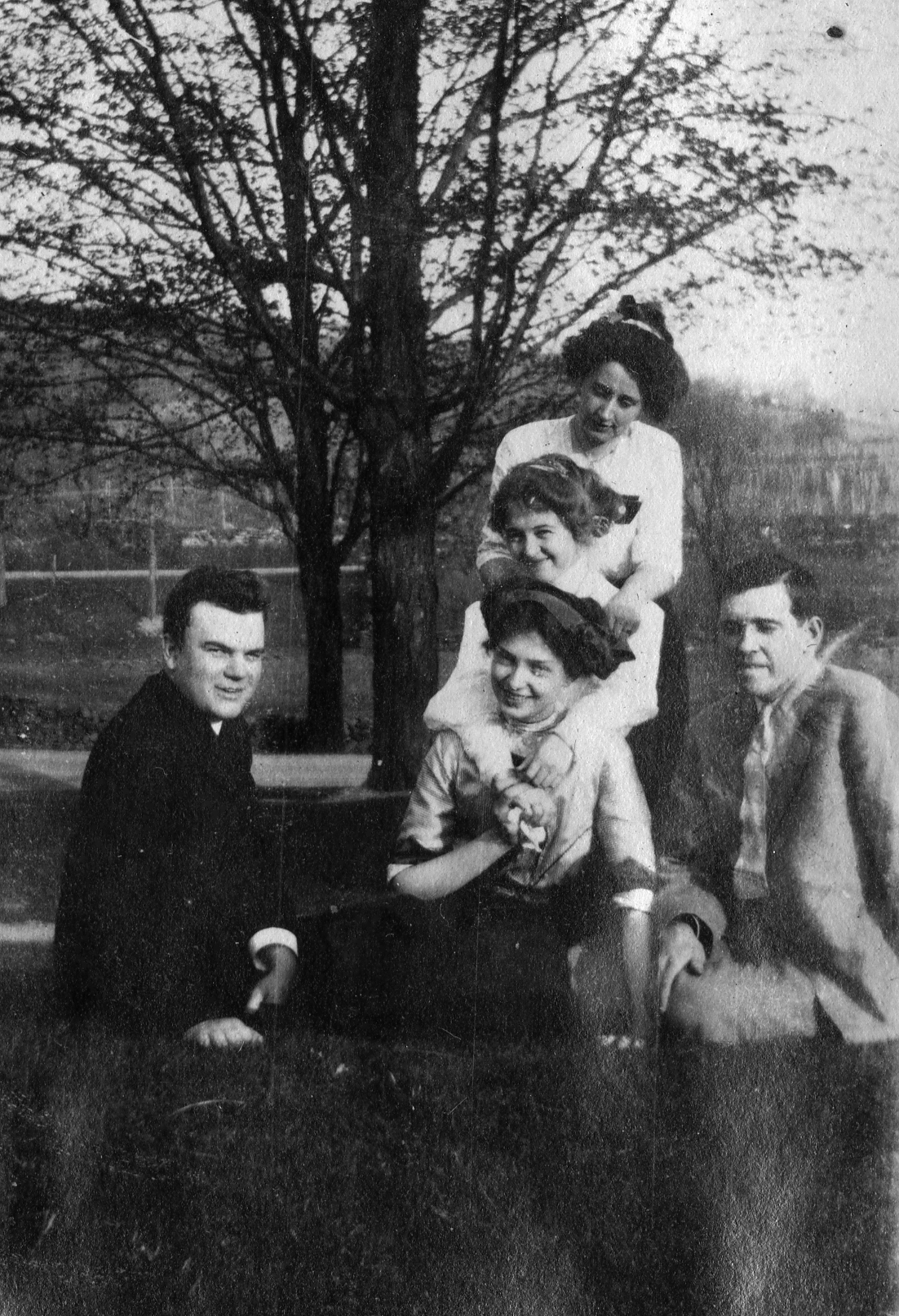 an old black and white po shows four people sitting on the ground