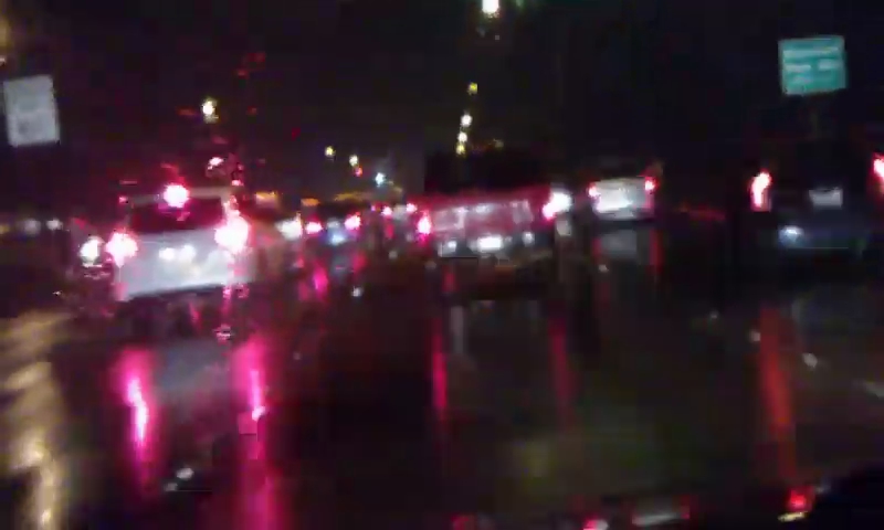 a blurry image of cars driving in the rain