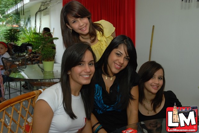 four smiling young women at a party together
