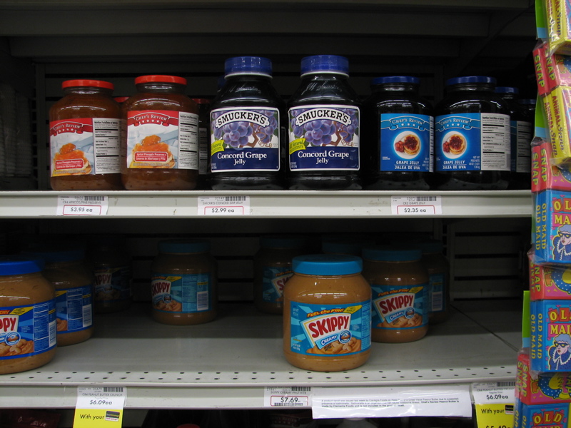 some jars of peanut er on shelves with labels
