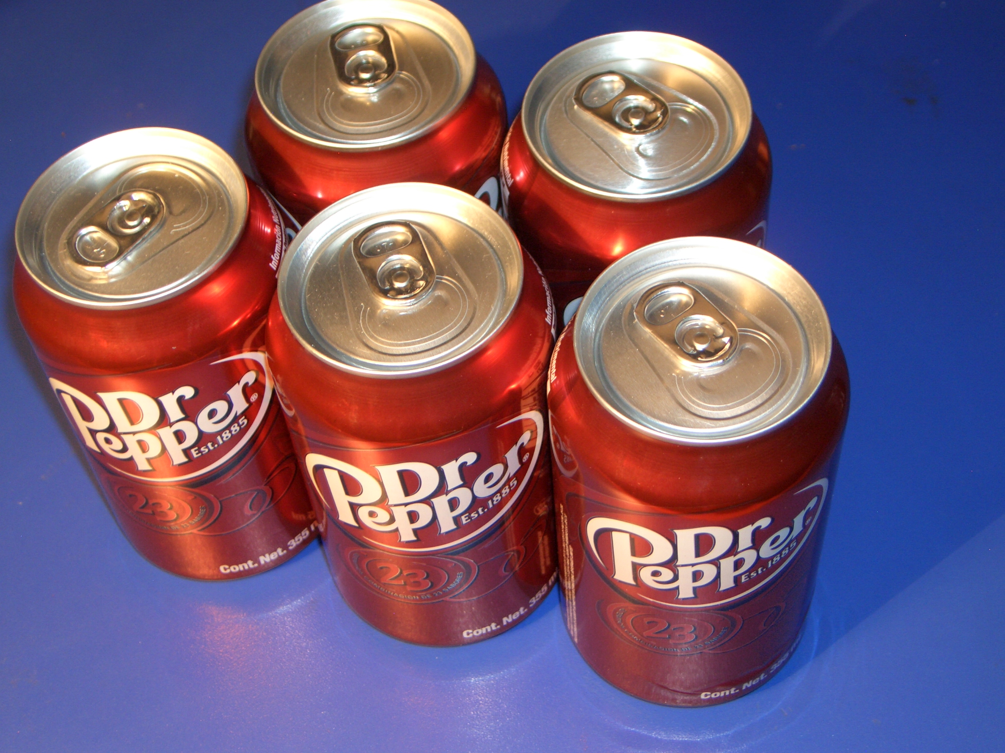 six red cans on a blue table
