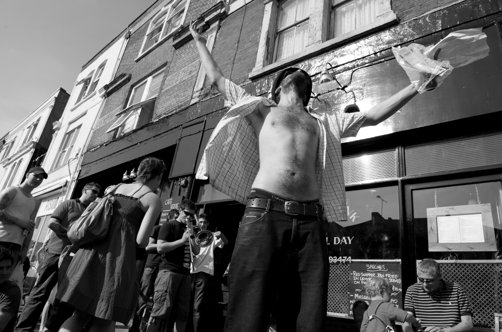 a man standing outside with his arms stretched out while holding a paper