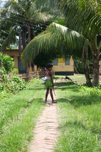 small girl walking on grass path in rural area