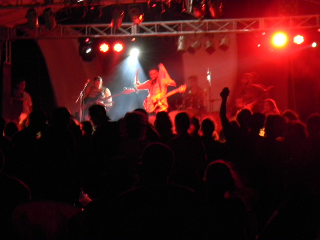 a band playing on stage with large crowd